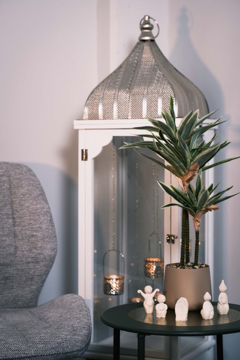 Coin décoré avec une grande lanterne blanche, une plante et des figurines